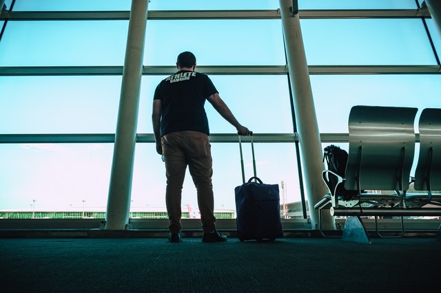 Muž s batožinou čaká v letiskovej hale pri okne.jpg